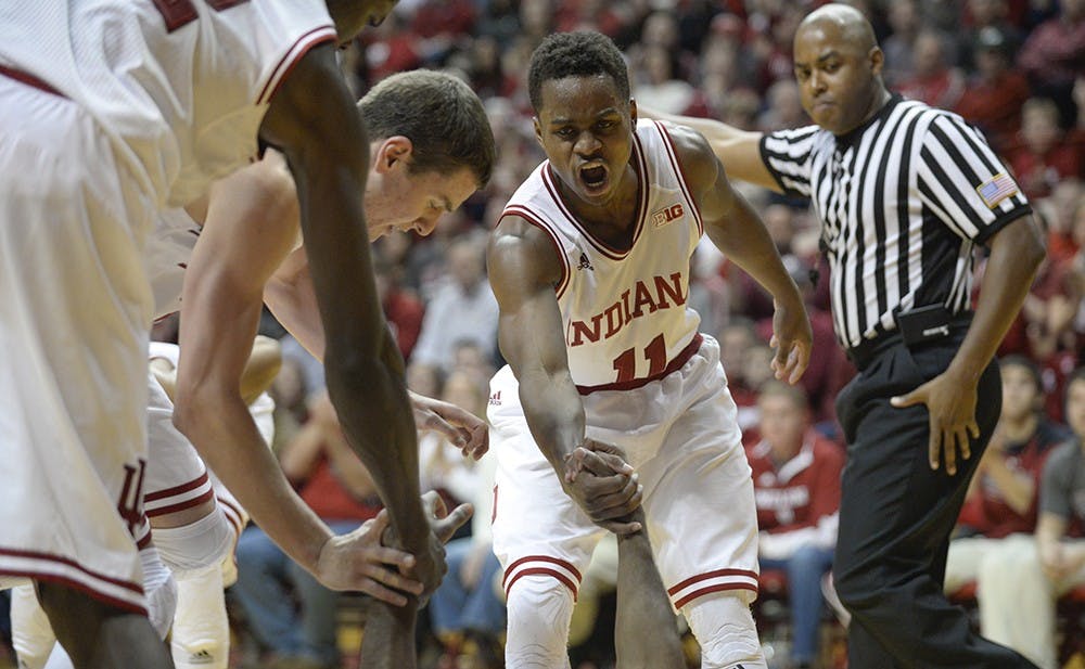 Junior guard Kevin "Yogi" Ferrell helps up freshman Robert Johnson after Johnson took a charge in the second half of IU's game against North Carolina Greensboro on Friday at Assembly Hall.