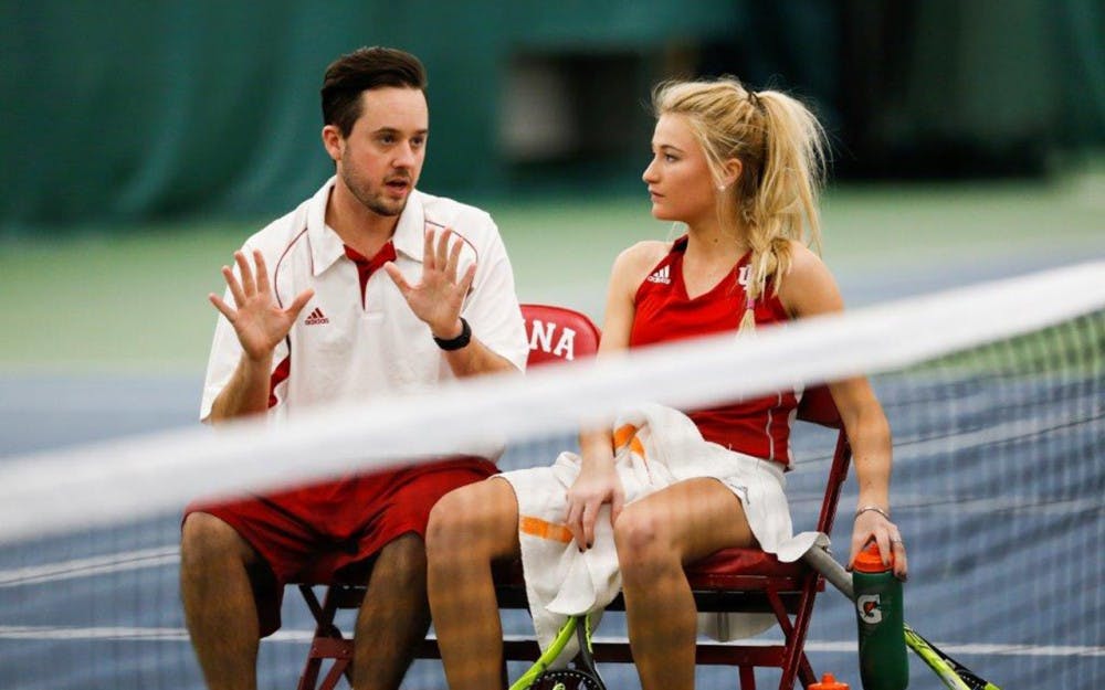 IU women's tennis assistant coach Ryan Miller sits and talks with then-sophomore Madison Appel during a match.