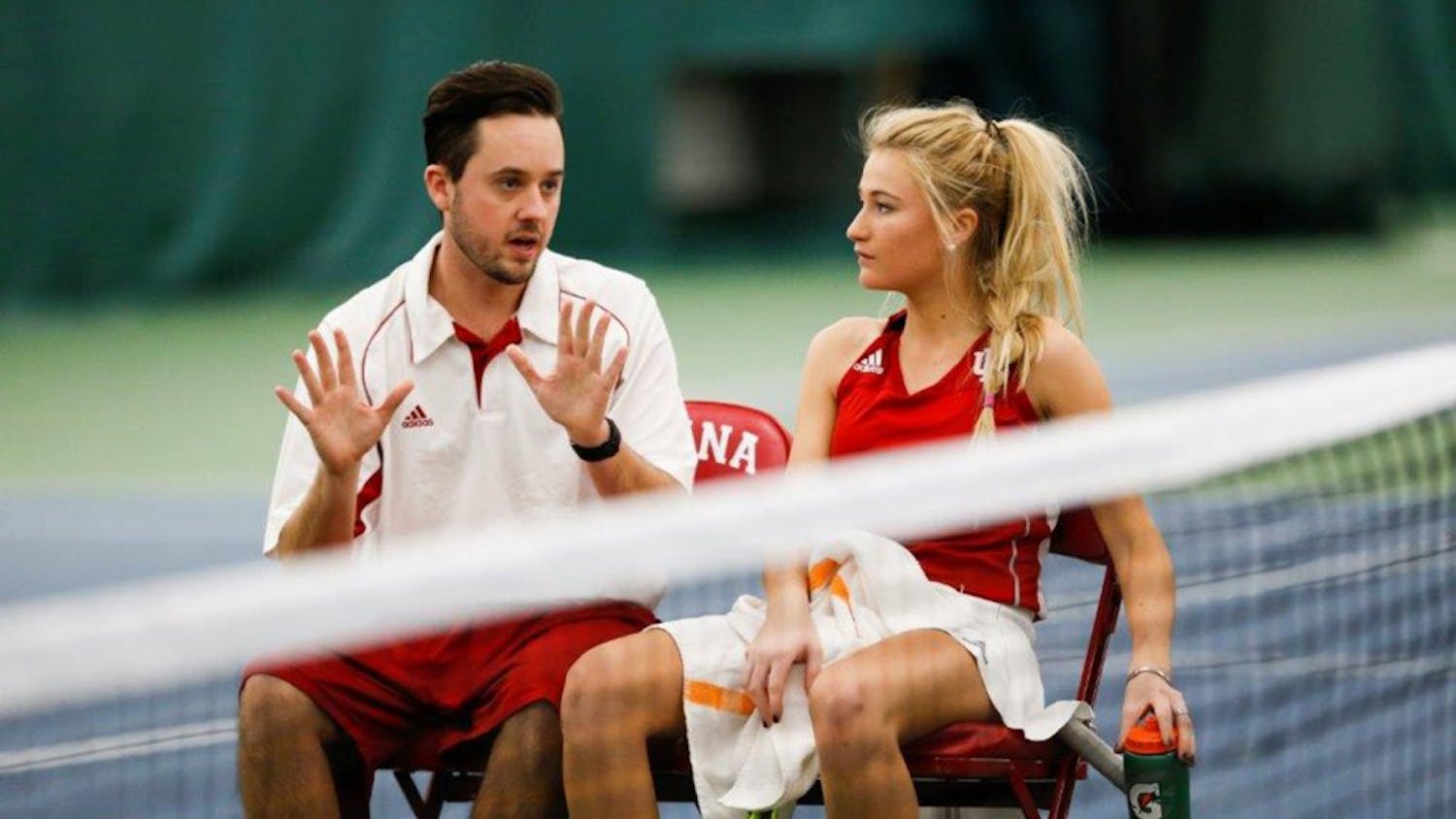IU women's tennis assistant coach Ryan Miller sits and talks with then-sophomore Madison Appel during a match.