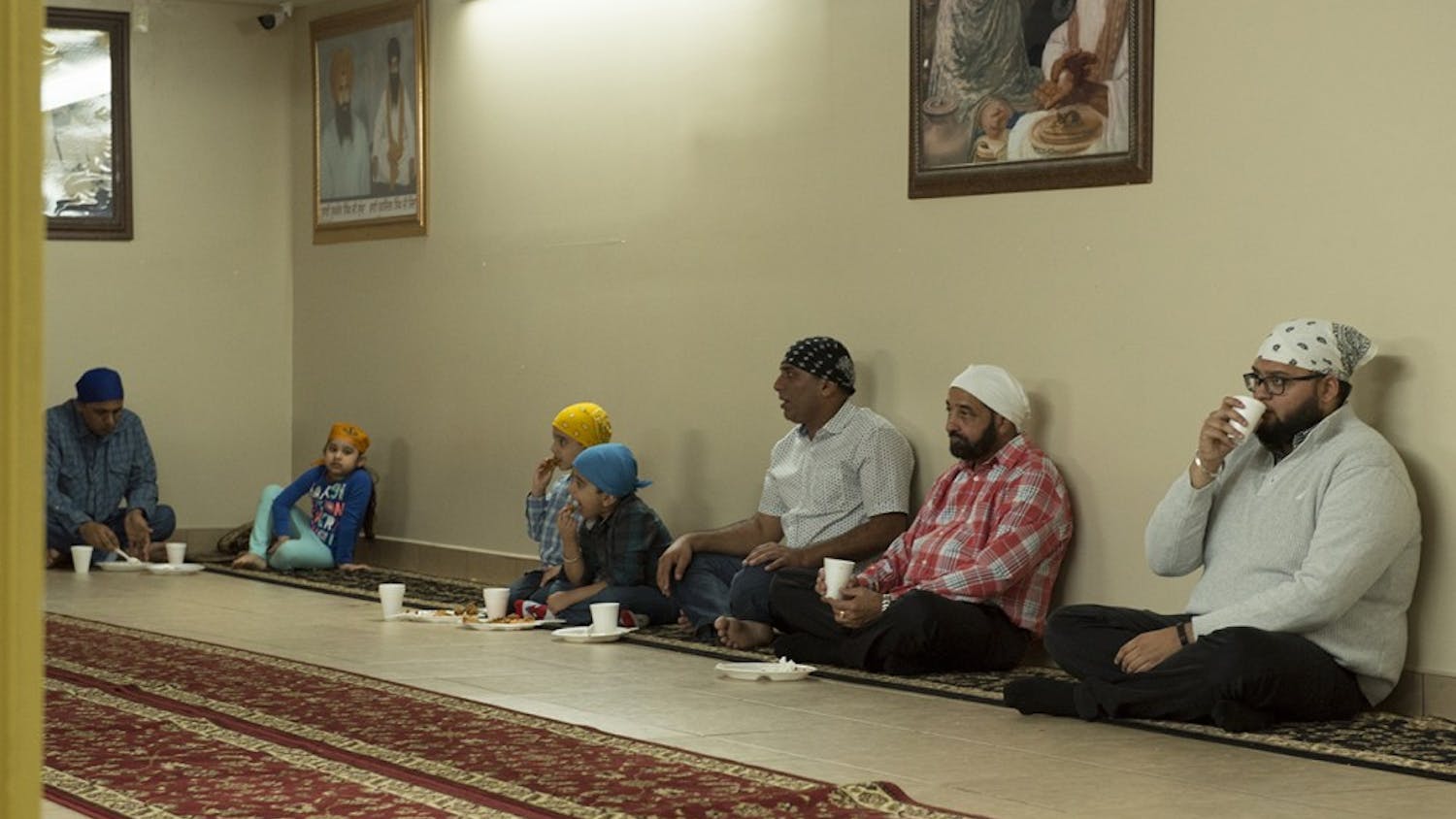 Sikhism practitioners having a meal at the basement of a Sikh Gurdwara in Fishers, Ind. They believe that having meals on the floor promotes equality. 
