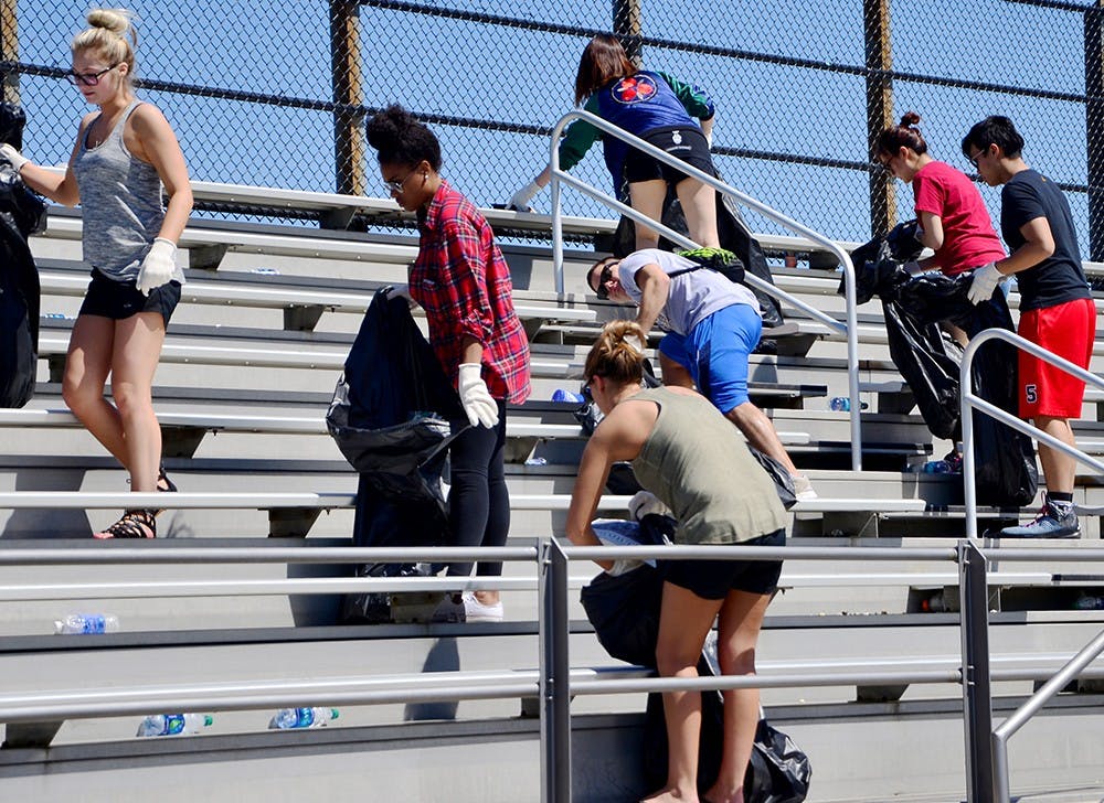 Students who have received a drinking violation ticket during the Little 5 weekend pick up trashes as a part of the pretrial diversion program Sunday at the Bill Armstrong Stadium 