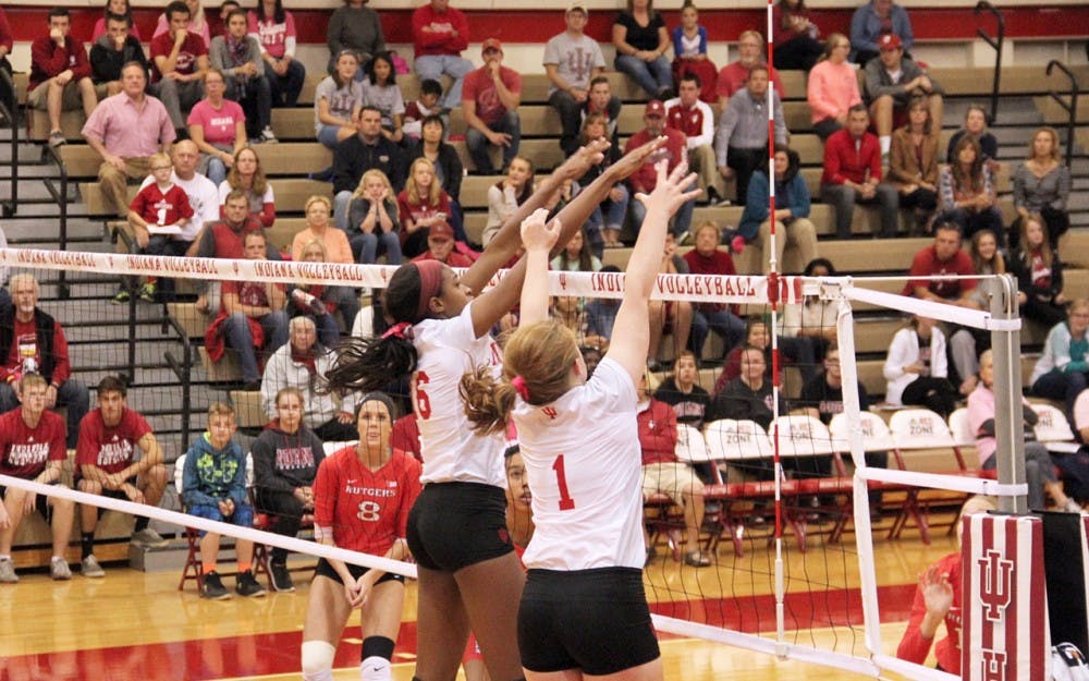 Deyshia Lofton (left) and Victoria Brisack from IU Hoosiers Volleyball defend the ball as they compete agaisnt Rutgers Scarlet Knights Friday night at the University Gym.