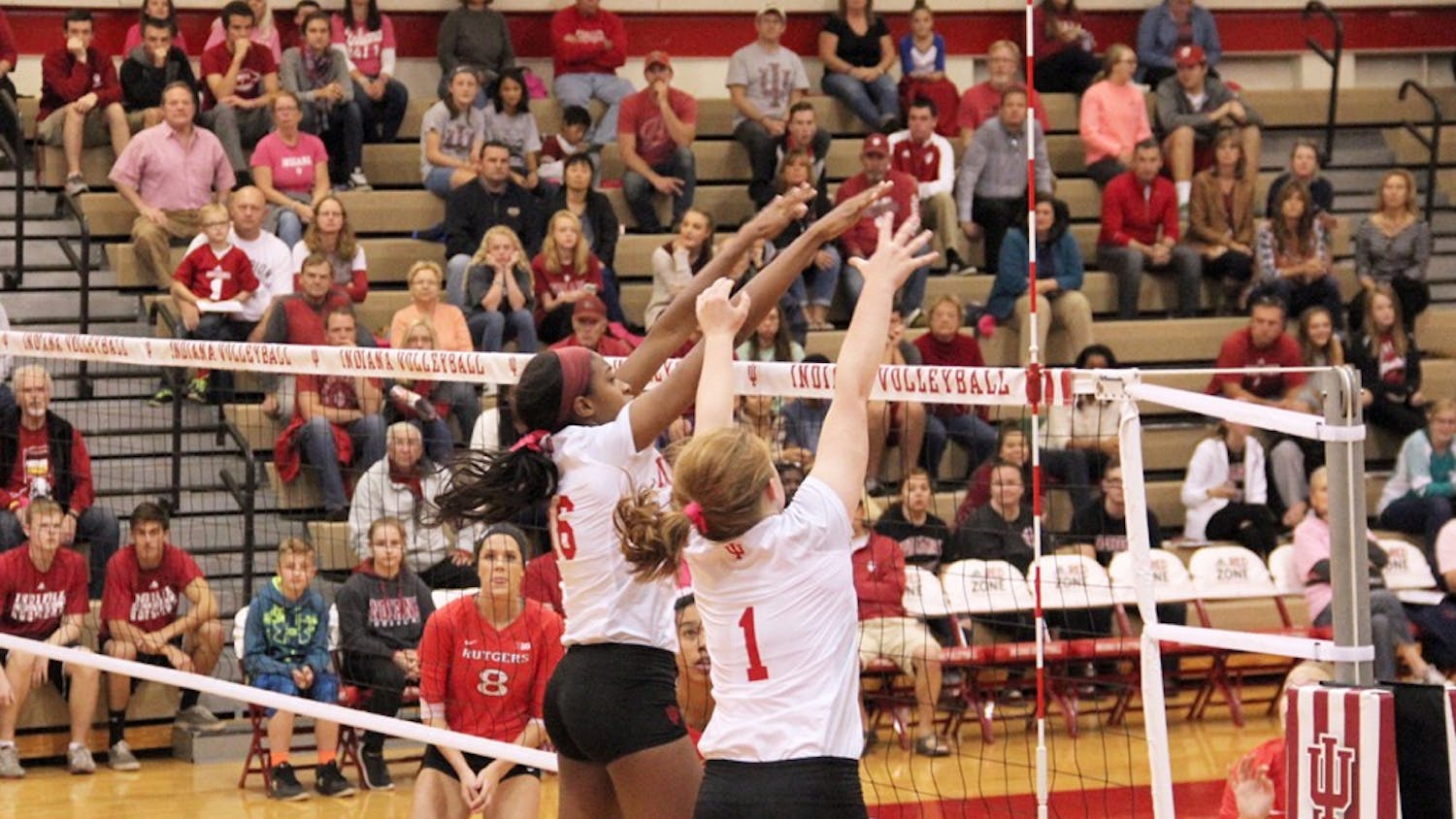 Deyshia Lofton (left) and Victoria Brisack from IU Hoosiers Volleyball defend the ball as they compete agaisnt Rutgers Scarlet Knights Friday night at the University Gym.