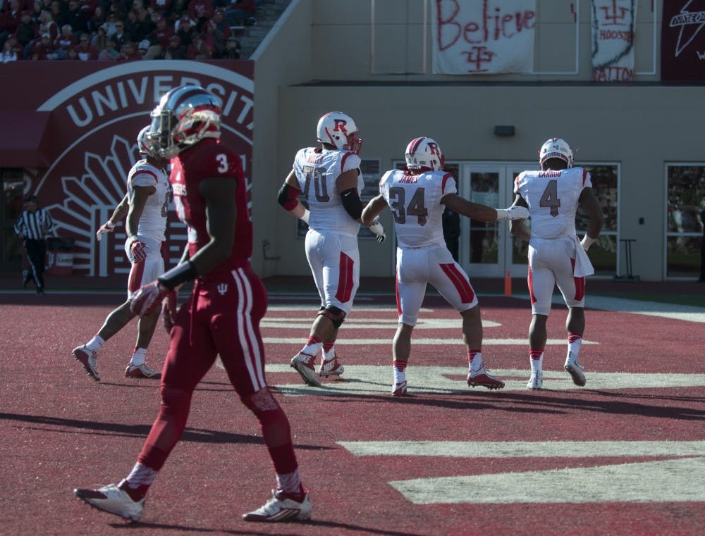 Cornerback Tyler Green walks of the field as Rutgers players celebrate after scoring Saturday at Memorial Stadium. The Hoosiers lost, 52-55.