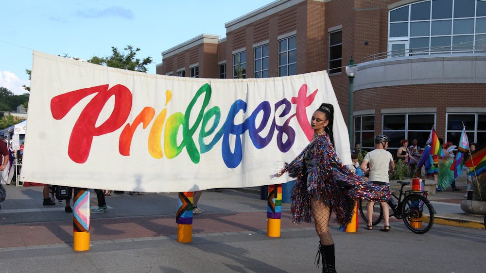 Drag artist Sanatana Sword poses by the Pridefest sign Aug. 27. Sword was one of the performers at Pridefest this year. 