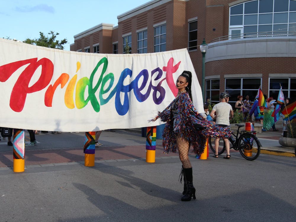 Drag artist Sanatana Sword poses by the Pridefest sign Aug. 27. Sword was one of the performers at Pridefest this year. 