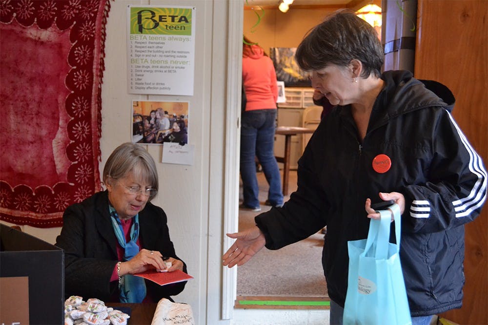  A volunteer hands a woman a piece of chocolate at the Brown County Humane Society's Annual Chocolate Walk in 2014. 
