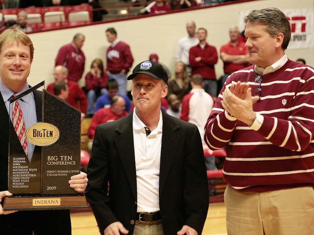 Athletic director Fred Glass, right, presents the Women's Big Ten Swimming and Diving Championship trophy to coaches Ray Looze, left, and Jeff Huber, center, during halftime of the Hoosiers 64-59 loss to No. 8 Michigan State March 6, 2009 night at Assembly Hall.