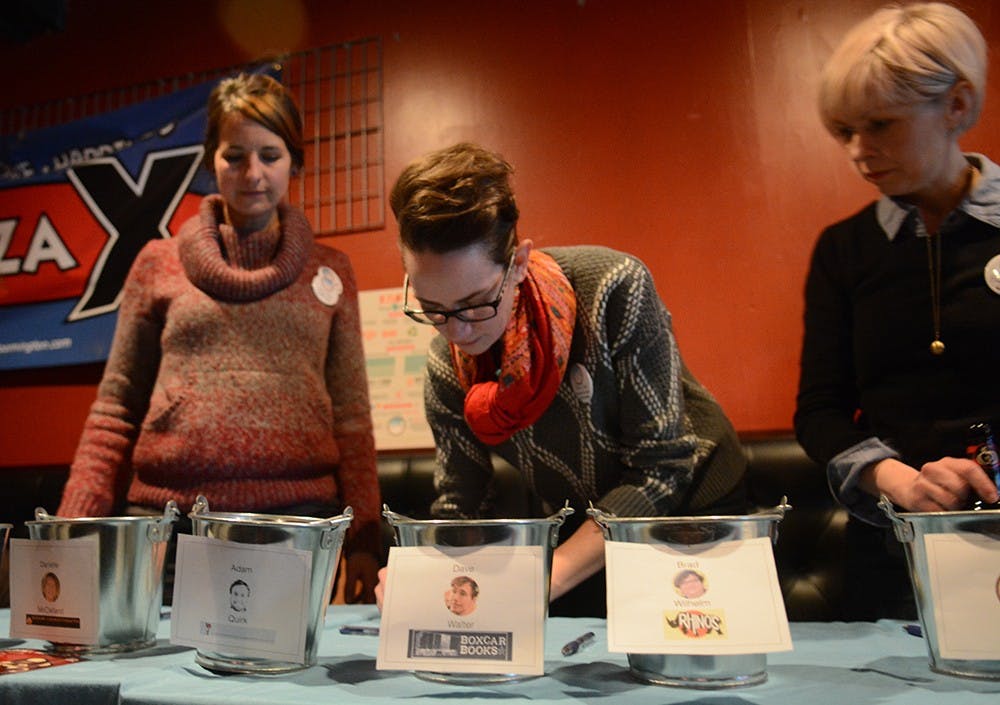 Board members of Local First Bloomington counts the money collected by each comedian during a charity event organized by Local First Bloomington, a non-profit organization, on Wednesday night. Local comedian Brad Wilhelm won the first Place and earned more than 345 dollars for Rhino’s Youth Center.   “It’s for a great cause,” Alison Zook (middle) said. 