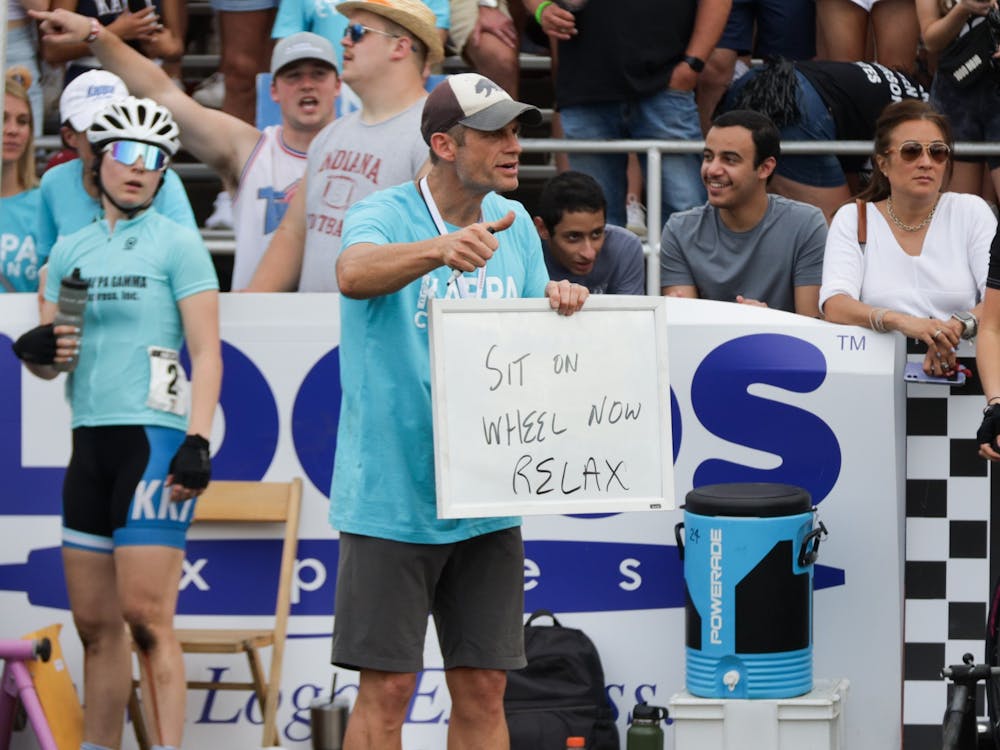 A father of a Kappa Kappa Gamma rider holds a sign in the pit April 22, 2022, at Bill Armstrong Stadium. Many pit and mechanic teams for sororities were made up of parents. 