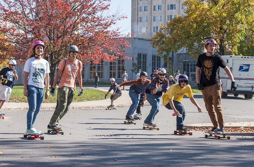 Members of the IU Longboarding Club race through campus on Oct. 25, 2014. The group is hosting a Slide Jam event this weekend and expects more than 100 people to attend. 