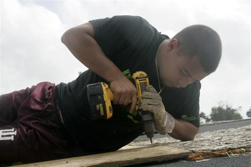 IU alum Mike Roque drills a sheet of OSB (oriented strand board) in order to patch up a roof at the Urban Life Missions camp on Saturday in Biloxi, Miss.