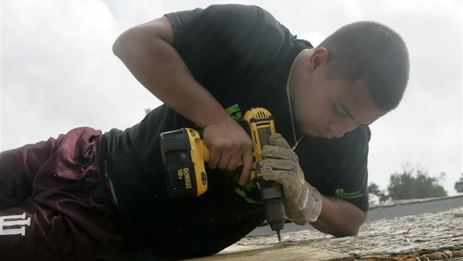 IU alum Mike Roque drills a sheet of OSB (oriented strand board) in order to patch up a roof at the Urban Life Missions camp on Saturday in Biloxi, Miss.