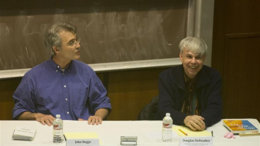 John Beggs and Douglas Hofstadter, two of the four panelists, discuss whether science and a belief in God are compatible on Wednesday in the Kelley Business School. 