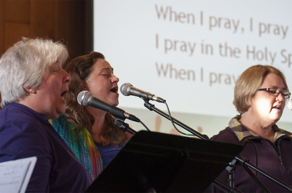 Ginger Curry, center, leads other members of Unity of Bloomington in song during the church's World Day of Prayer service on Thursday.