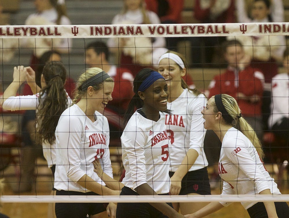 Members of the IU volleyball team celebrate after a point is scored during their game against Rutgers on Wednesday in University Gym.