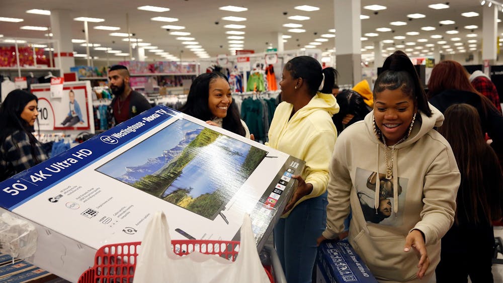 Shoppers Brittney McFaddenn, Rayneisha Yancey and Ja&#x27;shay Stagg bring a new television in their cart during Black Friday shopping Nov. 29, 2019, at Target in Carson, California. The Kelley School of Business recently released a study that found people are doing holiday shopping earlier than in years past.