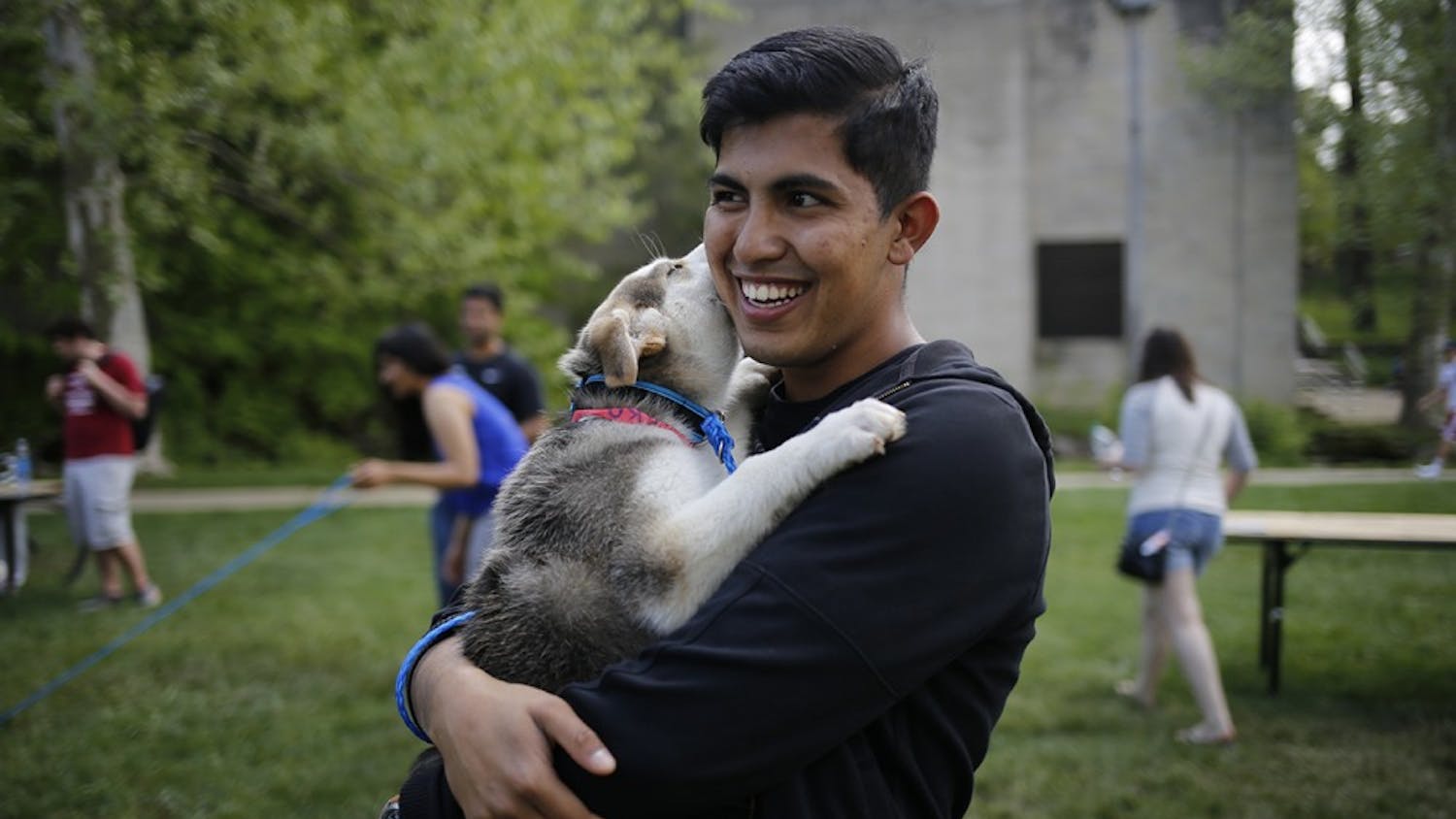 Nikhil Bharadwaj,  volunteer at the City of Bloomington Animal Shelter, holds his recently adopted puppy, Isco, during the Rent-A-Puppy event Thursday, April 28 at Dunn Meadow. The City of Bloomington Animal Shelter will be holding an event throughout the month of October, Adopt-A-Dog, that will reduce the adoption fees for all dogs during October. 