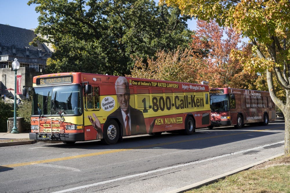 <p>Two buses wait to pick up students Oct. 15 on East Seventh Street. The bus routes are in the process of being changed for the 2020-21 school year. </p>