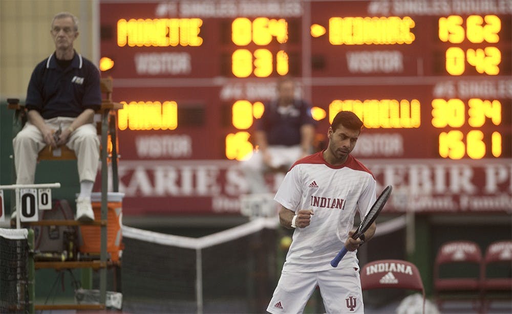 Sophomore Raheel Manji punches the air in celebration after getting a point against Washington's Enzo Sommer on Friday evening at the IU Tennis Center. Manji beat Sommer 4-6, 6-4, 6-4.