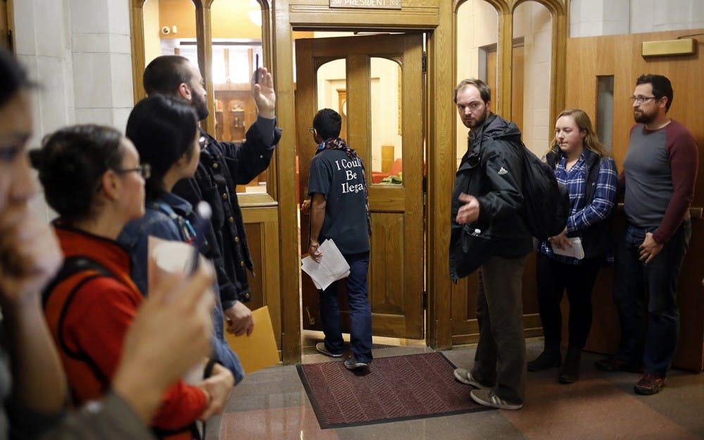 Willy Palomo delivers a list of demands to President McRobbie during a rally for a Sanctuary Campus Wednesday. "We are demanding that they meet with undocumented students by Tuesday, November 29th, or we will give them hell," Palomo later said. 
