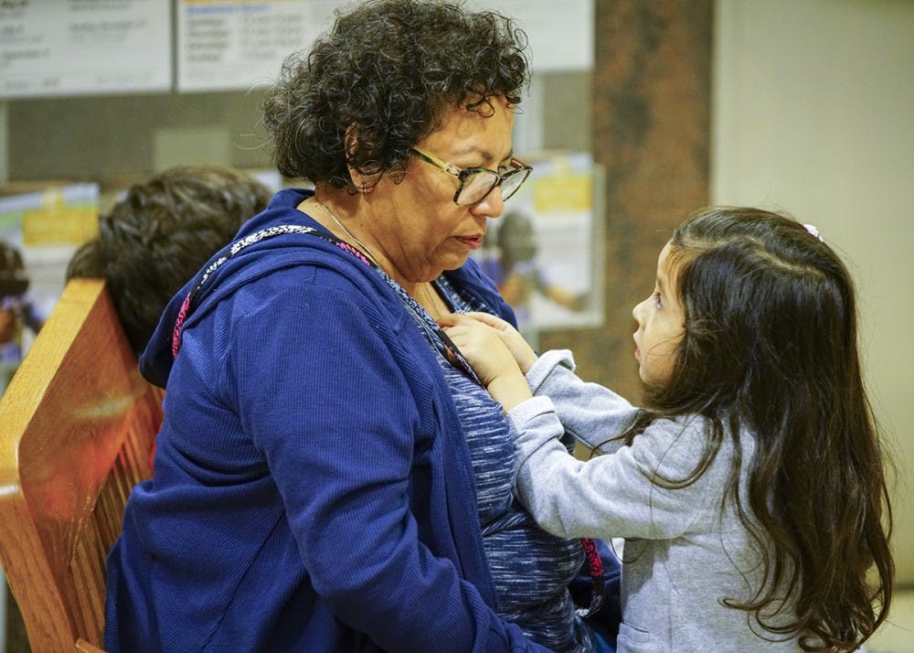 Elosia plays with her grandmother Rochelle Martin’s necklace during the Hispanic Heritage Day Celebration on Sunday afternoon in the Monroe County Public Library.&nbsp;