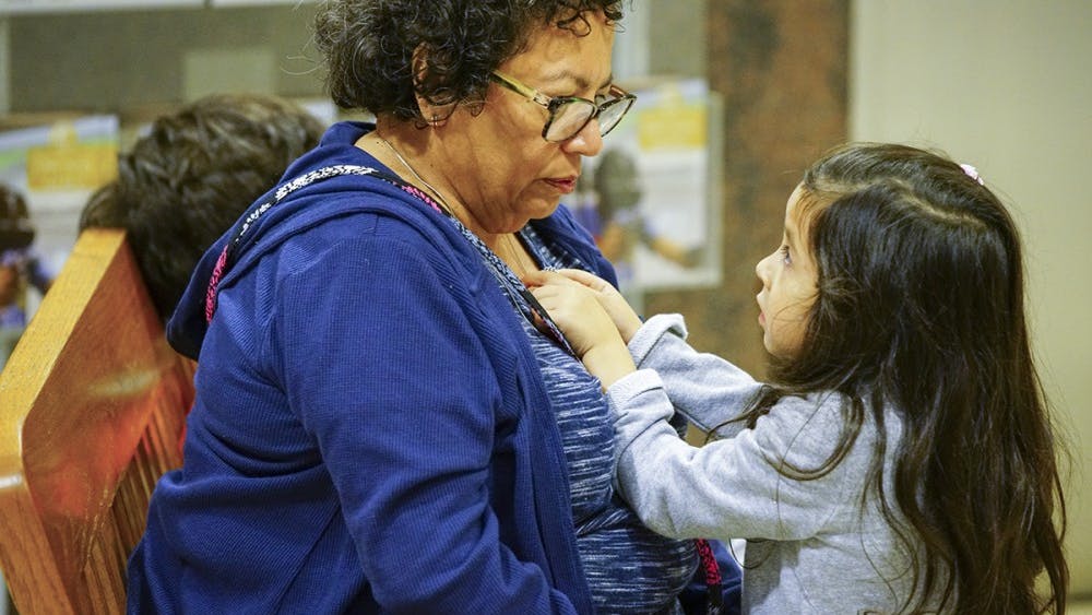 周日下午在门罗县公共图书馆举行的西班牙传统日庆祝活动上，埃洛西亚玩着她祖母罗谢尔·马丁的项链。