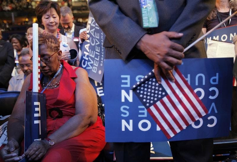 Delegate Carrie Austin, of Chicago, bows her head during the benediction at the close of the opening session of the Democratic National Convention Monday in Denver.