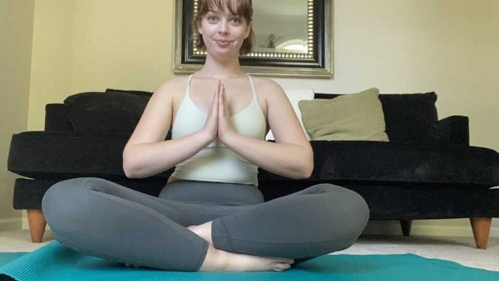 Sophomore Curren Gauss practices yoga in her home Sunday. Gauss said yoga practices such as ujjayi have helped her lungs heal from the after-effects of COVID-19. 
