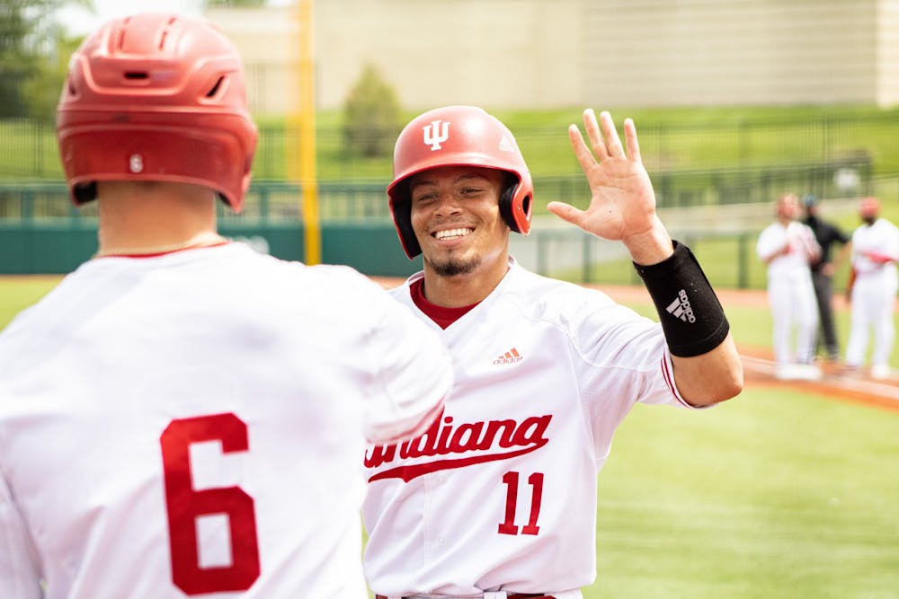<p>Then-senior catcher Collin Hopkins high-fives sophomore outfielder Grant Richardson after scoring against Iowa on May 2, 2021. Indiana will play Miami University at 4 p.m. Tuesday.</p>