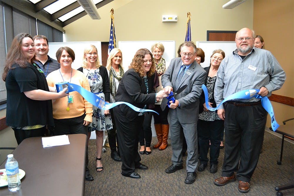 Employees of the Monroe County Prosecutor's Office Child Support Program cuts a ribbon symbolizing the opening of their new facility. 