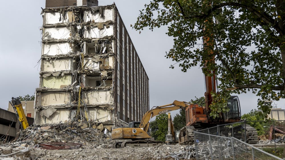 A construction crew works on razing IU&#x27;s historic Poplars Building on Aug. 30, 2022, along East Seventh Street. The building was originally built in 1964 to be a luxury dorm for female students before it transitioned into a hotel in 1967.