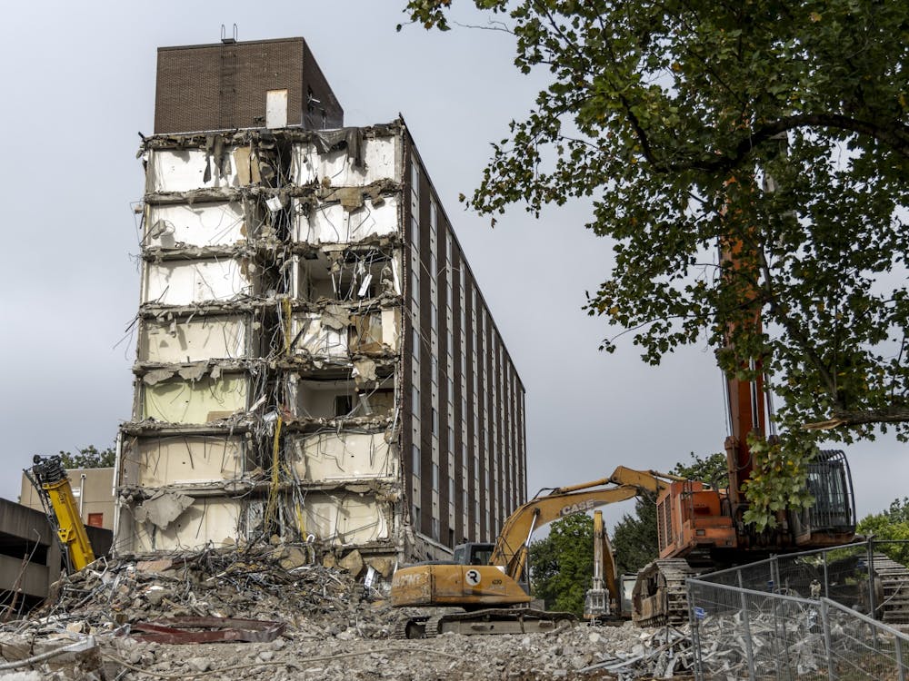 A construction crew works on razing IU&#x27;s historic Poplars Building on Aug. 30, 2022, along East Seventh Street. The building was originally built in 1964 to be a luxury dorm for female students before it transitioned into a hotel in 1967.