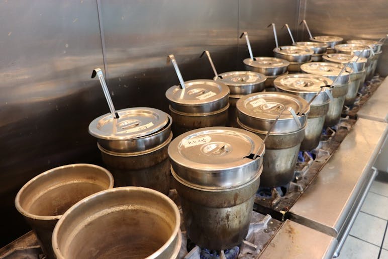 Toward the back of the restaurant, there is a kitchen where the soup is cooked. A variety of soups are constantly simmering over burners. &nbsp;