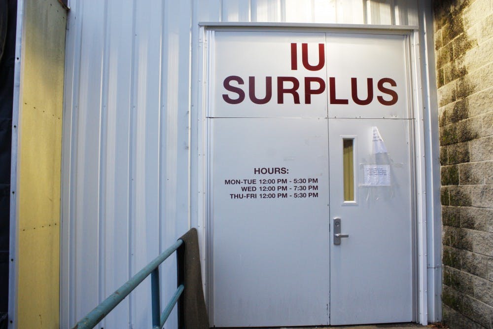 The front doors of Indiana University Surplus Stores display the store's hours. The store is only open Monday through Friday. Monday, Tuesday, Thursday and Friday the store is open 12 - 5:30 p.m., and Wednesday 12 - 7:30 p.m. The warehouse is located at 2931 E 10th Street.