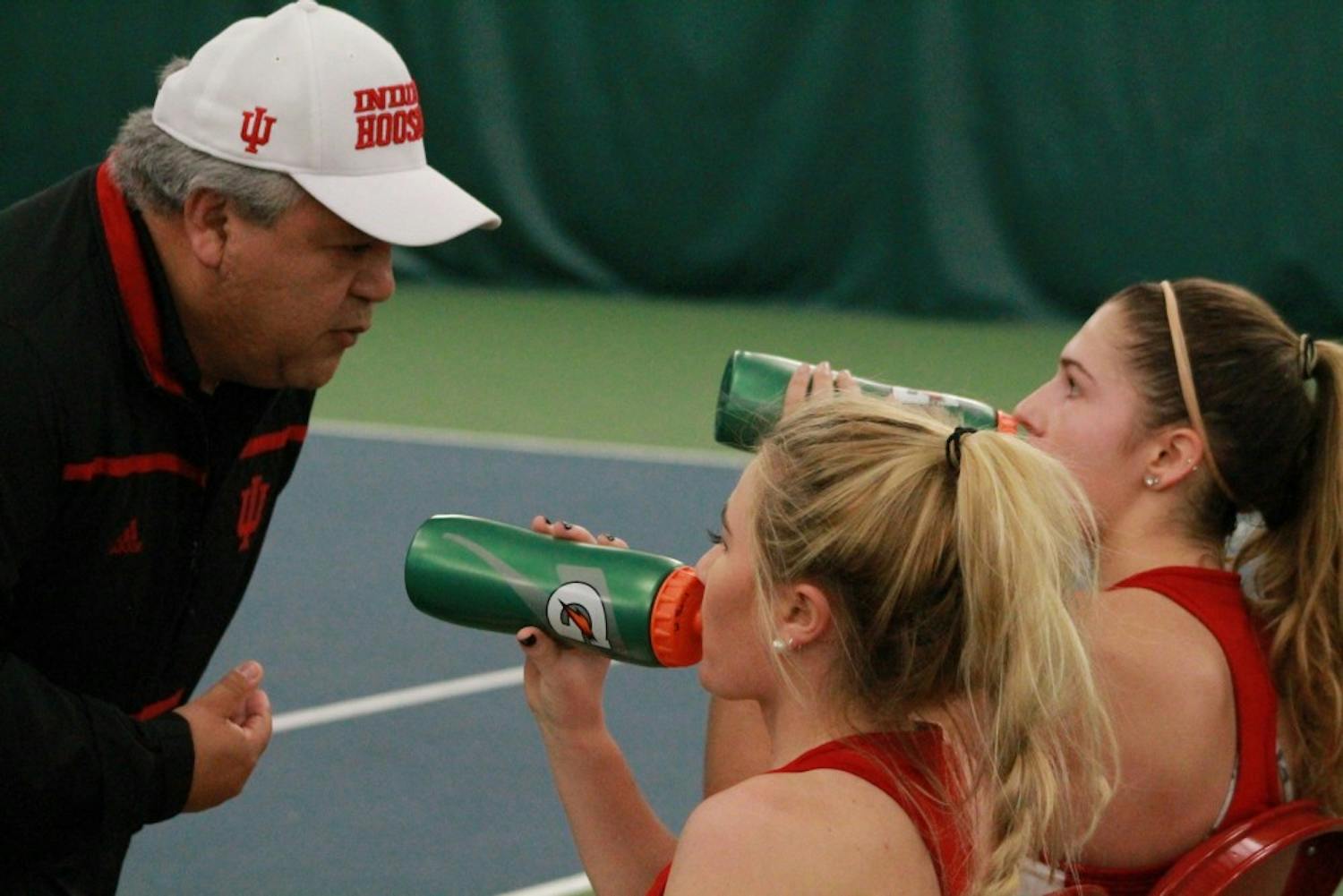 Head coach Ramiro Azcui talks with then-sophomores, now juniors, Madison Appel and Natalie Whalen in February at a match against DePaul. This will be Azcui's second season as head coach.&nbsp;