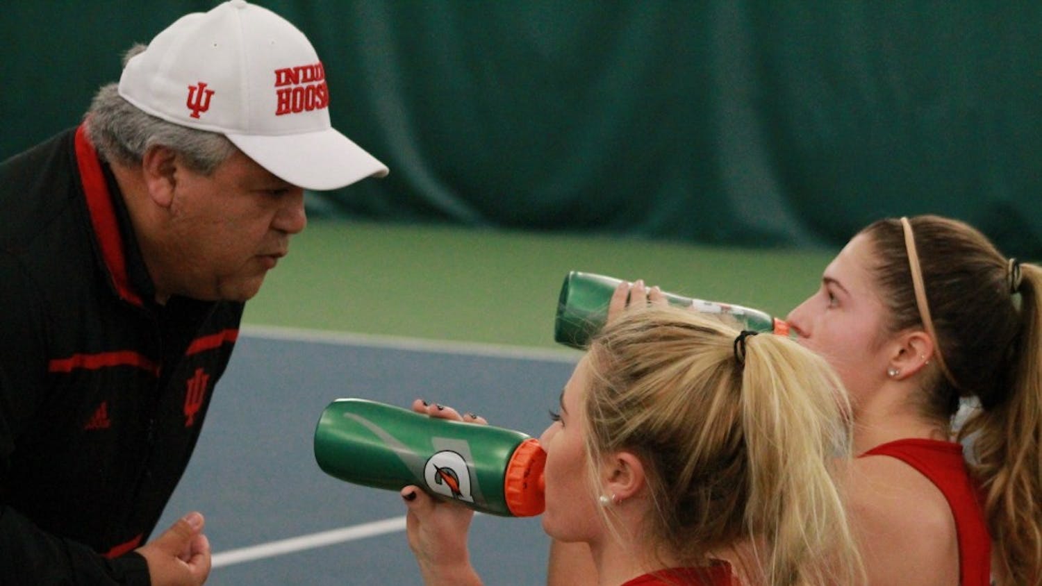 Head coach Ramiro Azcui talks with then-sophomores, now juniors, Madison Appel and Natalie Whalen in February at a match against DePaul. This will be Azcui's second season as head coach. 