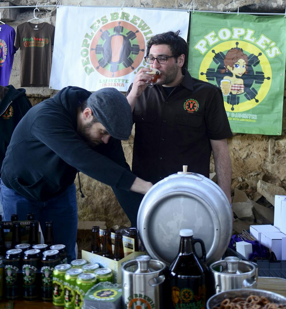 Phill Green takes a sip of the Imperial Pilsner while setting up the People’s Brewing Company’s booth at the 5th Annual Bloomington Craft Beer Festival on Apr. 11, 2015.
