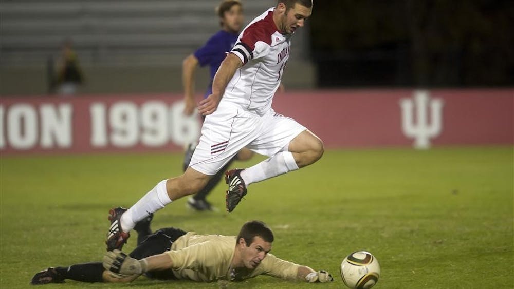Junior forward Will Bruin jumps over Northwestern goalkeeper Jonathan Harris during IU's 3-2 win against the Wildcats on Sunday at Bill Armstrong Stadium.