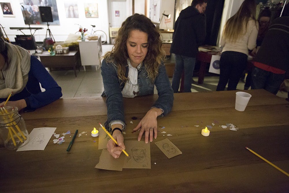 Chelsea Sanders tries blind painting in Blueline Gallery on Friday night.
