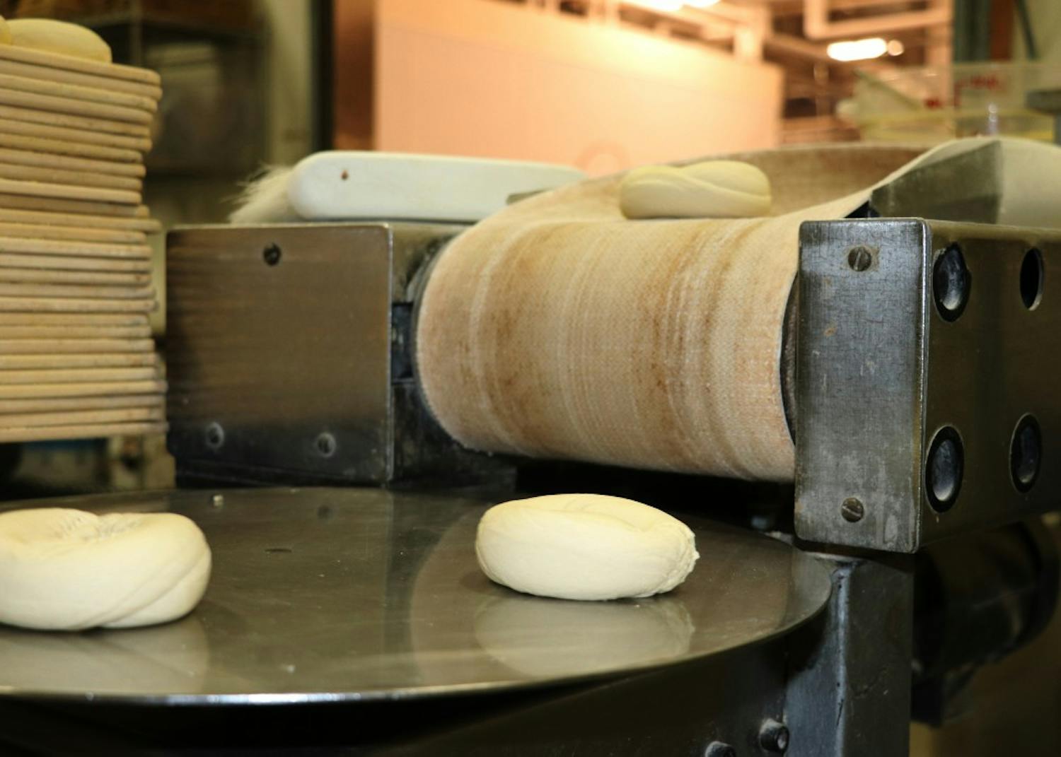 On the other end of the machine, bagels come out and land on a spinning disc before being placed on racks. Tritan said they use 500 pounds of flour a day on average.