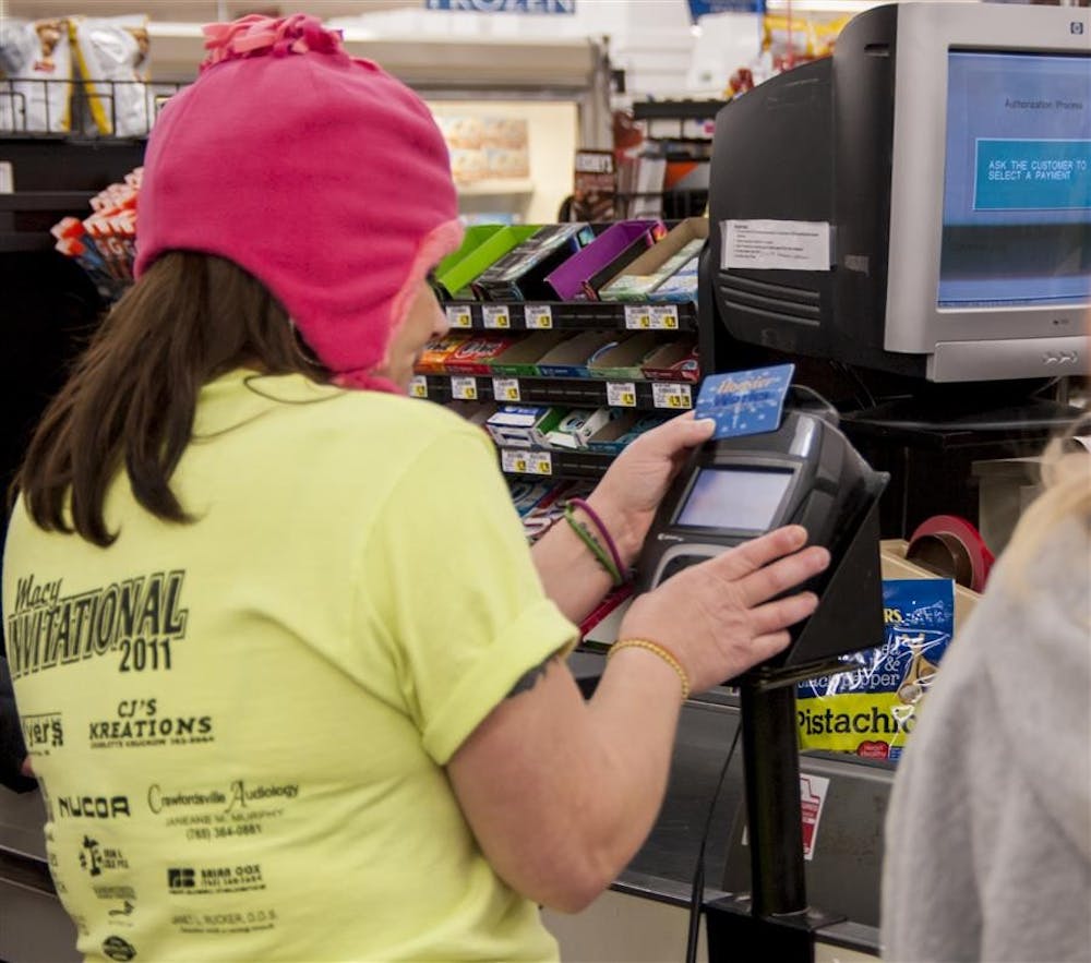 <p>Cassie Winders, 33-year-old single mother of four, uses her EBT card to purchase food for dinner Nov. 18, 2013, at Kroger. Indiana is adding two new benefits to the Supplemental Nutrition Assistance Program, commonly known as food stamps.</p>