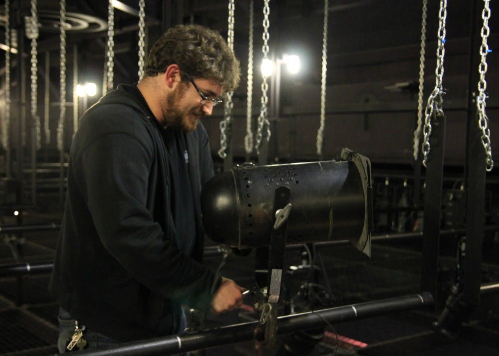 Lighting designer Anthony Stoeri hangs lights above the Wells-Metz Theater along with his crew. Stoeri will be the master electrician and lighting designer for the upcoming show, "Peter and the Star Catcher."