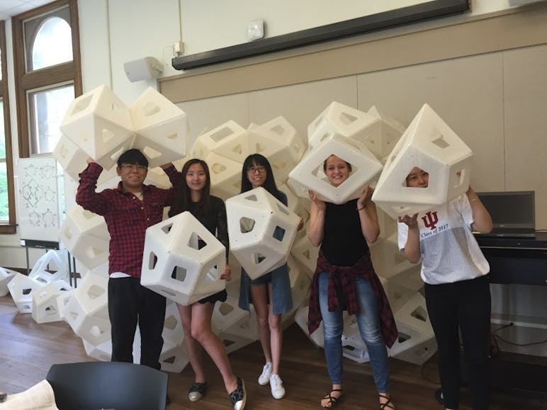 Students pose with individual pieces of the "Synergia", a public architectural pavilion, before it is put together in Columbus, Indiana.&nbsp;
