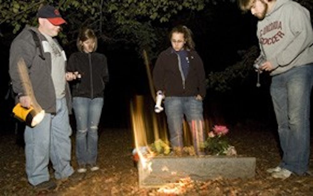 WEEKEND ghost hunters Brian J. McFillen, Allie Townsend, Sara Amato and Joe Wetzel survey a tombstone at Stepp Cemetary. Photo by David Corso