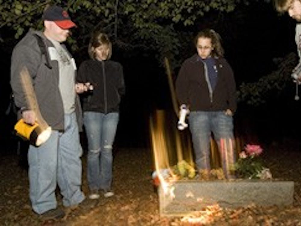 WEEKEND ghost hunters Brian J. McFillen, Allie Townsend, Sara Amato and Joe Wetzel survey a tombstone at Stepp Cemetary. Photo by David Corso
