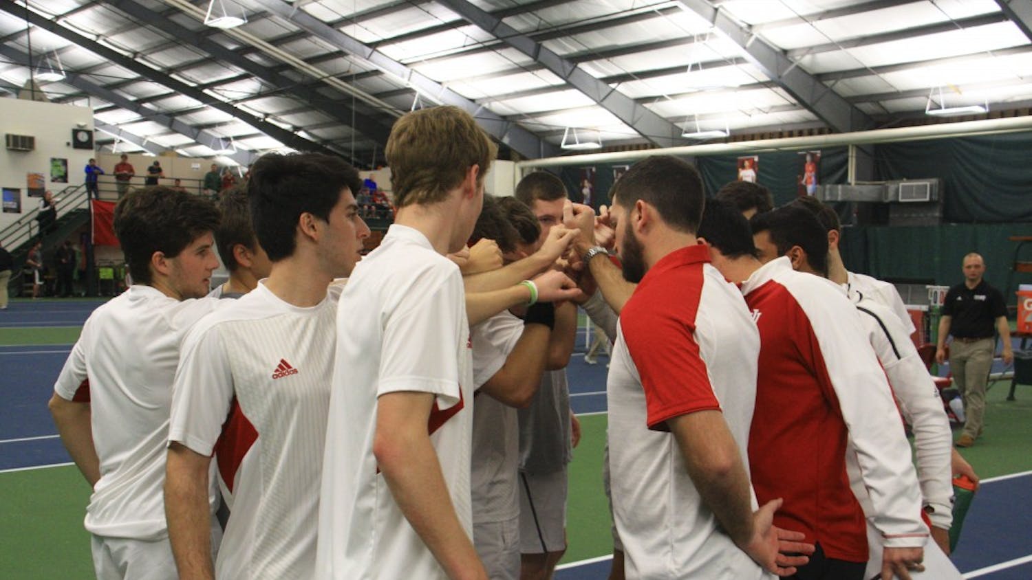 IU's men's tennis team gathers in a circle with coaches before a men's singles match against Purdue at the IU Tennis Center in 2017.&nbsp;