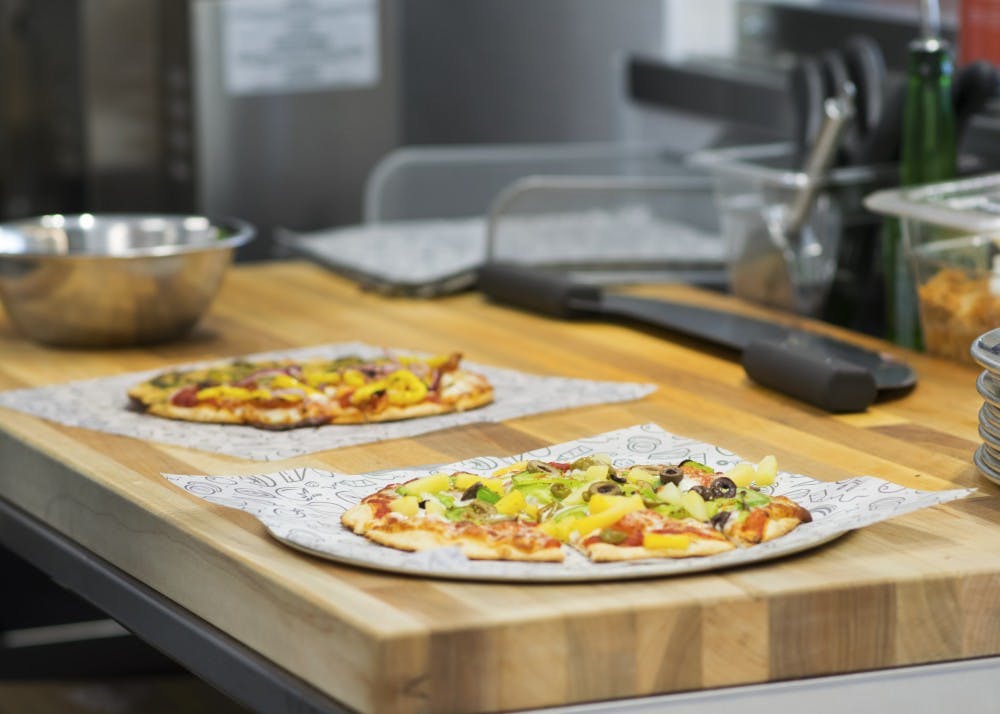 Sliced pizzas rest on plates, awaiting delivery to customers who wait in the dining area. "We care about what you're eating, and we care about how it looks," Elpers said. "We really want this to be a fully customized opportunity for you. It's all about the experience here, and you're not going to get it from another pizza place."