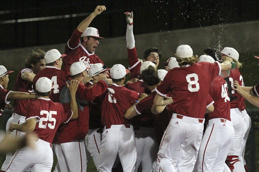 IU players run to celebrate with junior outfielder Craig Dedelow after their win against Northwestern on Friday night. THe Hoosiers won 4-3.
