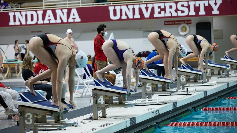 Indiana University swimmers get ready on their blocks to swim in the women&#x27;s 200-meter fly race on Jan. 28, 2022, at the Counsilman Billingsley Aquatic Center. Indiana will send 14 divers to the NCAA Zone C Diving Championships from Monday through Wednesday in Ann Arbor, Michigan.